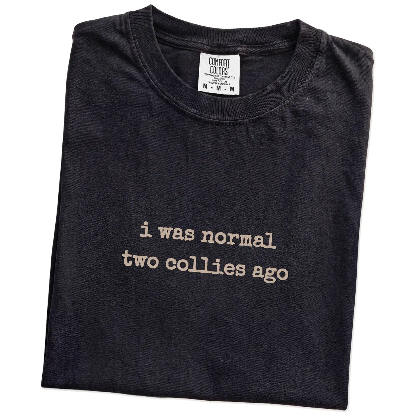 Folded Black Comfort Colors® T-shirt showing i was normal two collies ago lettering
