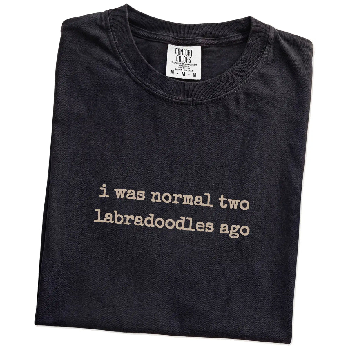 Folded Black Comfort Colors® T-shirt showing i was normal two labradoodles ago lettering