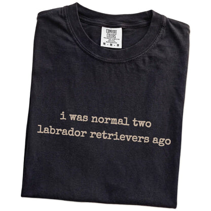Folded Black Comfort Colors® T-shirt showing i was normal two labrador retrievers ago lettering