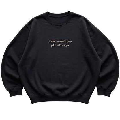 Black I Was Normal Two Pitbulls Ago sweatshirt laid flat