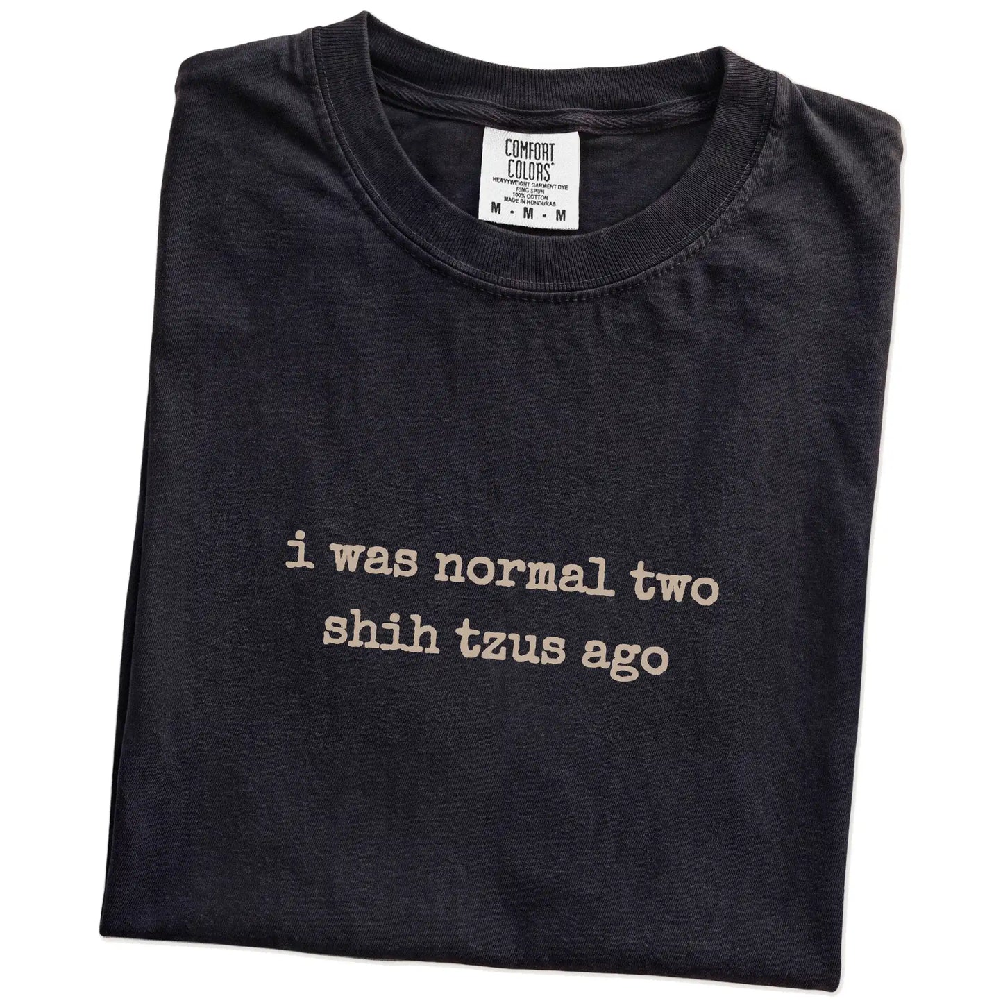 Folded Black Comfort Colors® T-shirt showing i was normal two shih tzus ago lettering