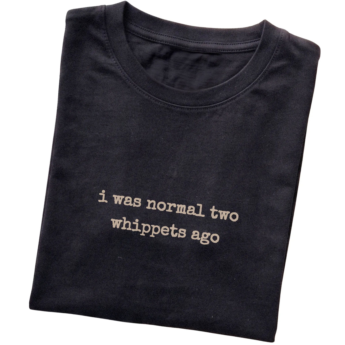 Black I Was Normal Two Whippets Ago T-shirt folded to show the printed design