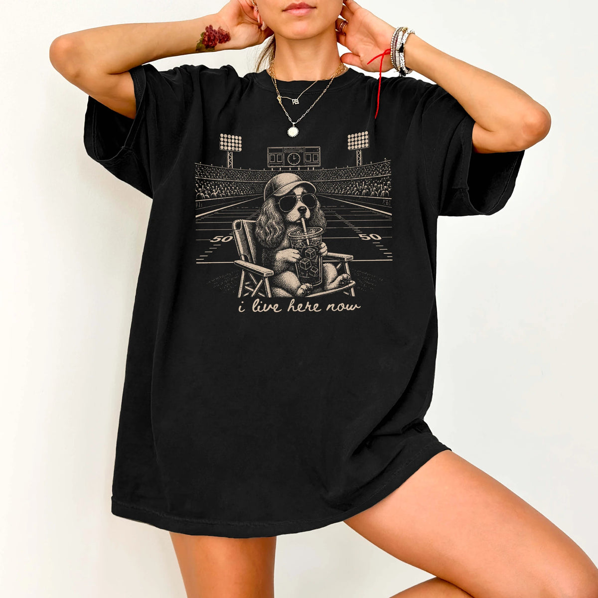Model wearing a Black Comfort Colors® T-shirt featuring Cavalier King Charles Spaniel claiming the football field with “I Liv