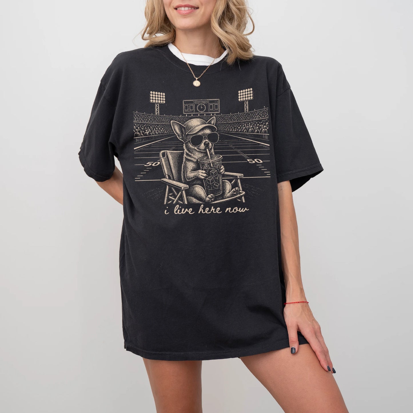 Model wearing a Black Comfort Colors® T-shirt featuring Chihuahua claiming the football field with “I Live Here Now” letterin