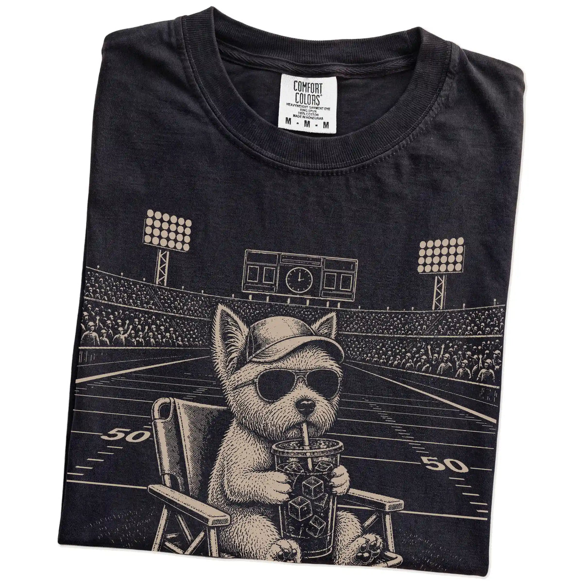 Folded Black Comfort Colors® T-shirt showing Westie claiming the football field with “I Live Here Now” lettering
