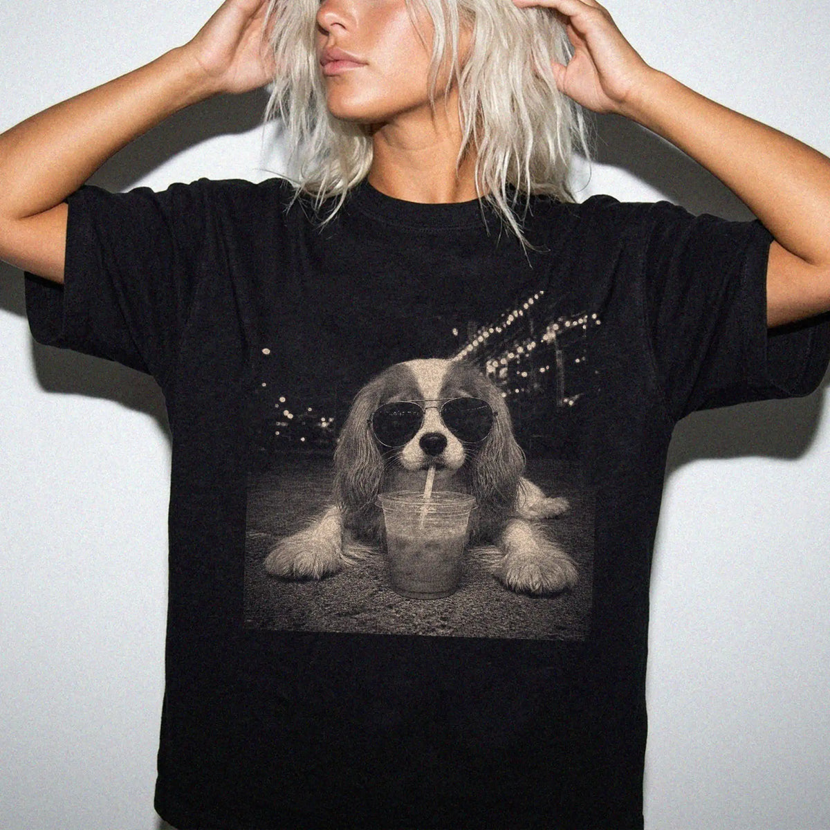 Model wearing a Black Comfort Colors® T-shirt featuring Cavalier King Charles Spaniel with iced coffee in a retro grunge desi