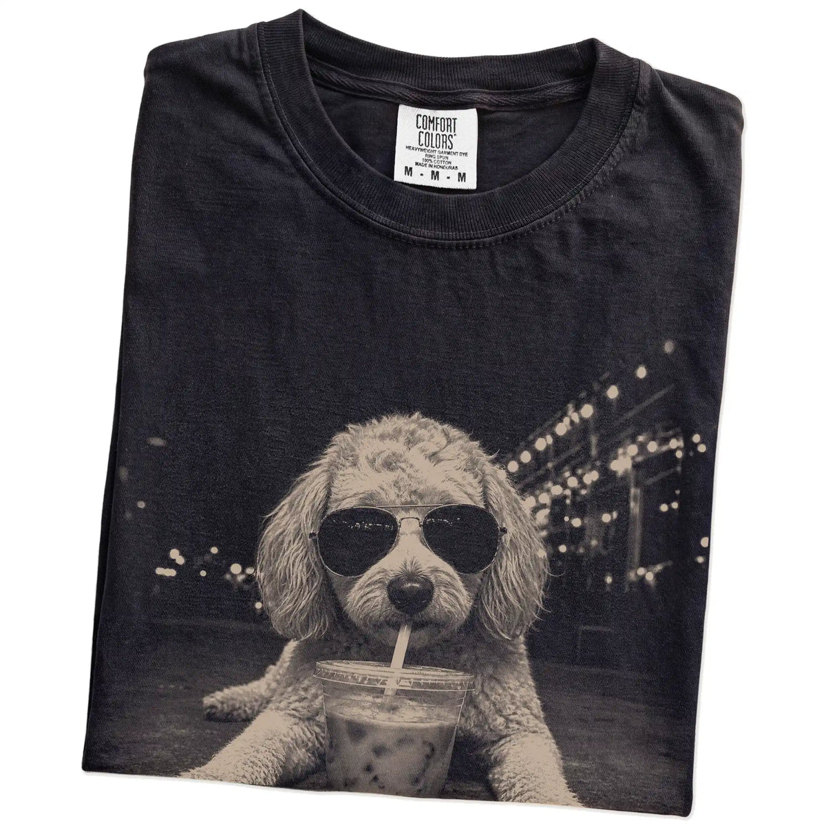 Folded Black Comfort Colors® T-shirt showing Goldendoodle with iced coffee in a retro grunge design