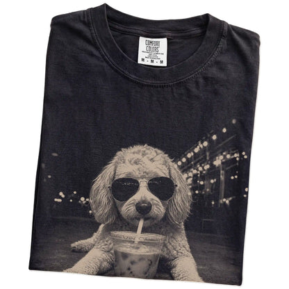 Folded Black Comfort Colors® T-shirt showing Goldendoodle with iced coffee in a retro grunge design