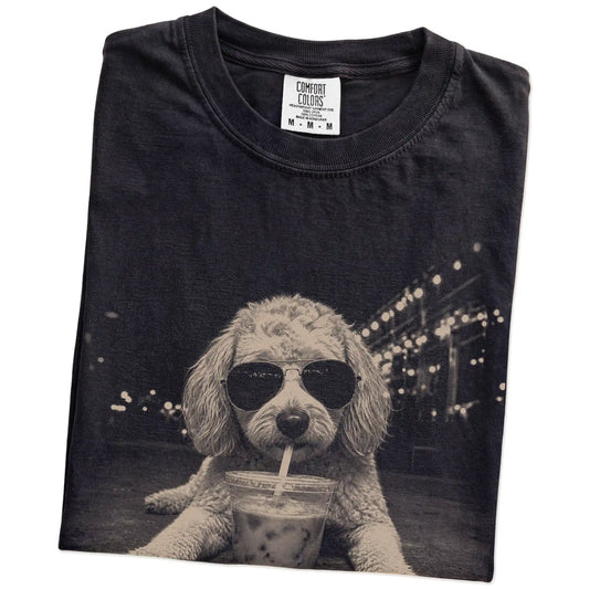 Folded Black Comfort Colors® T-shirt showing Goldendoodle with iced coffee in a retro grunge design
