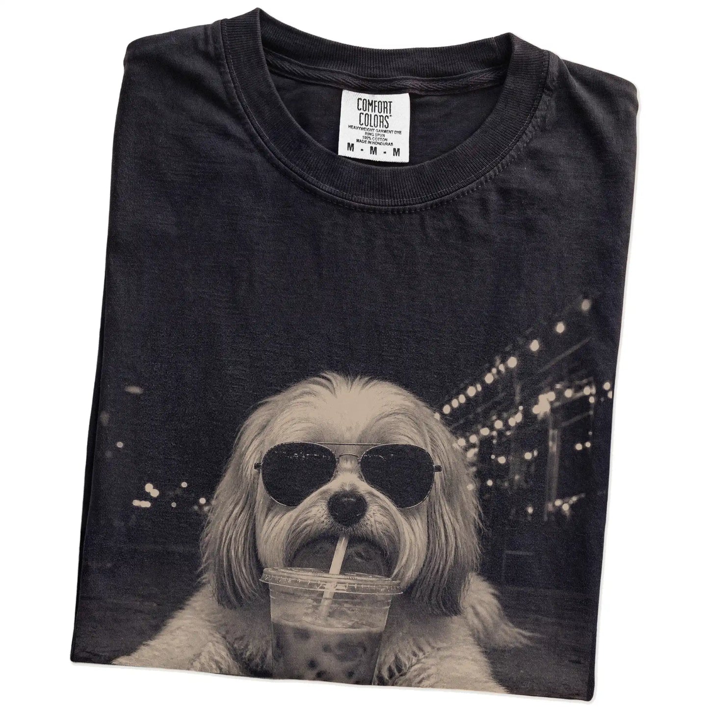 Folded Black Comfort Colors® T-shirt showing Havanese with iced coffee in a retro grunge design