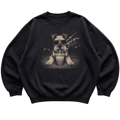 Schnauzer wearing aviator sunglasses and drinking iced coffee on a Black Gildan Heavy Blend Crewneck Sweatshirt, flat lay view
