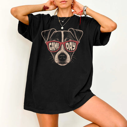 Model wearing a Black Comfort Colors® T-shirt with jack russell wearing red game day sunglasses