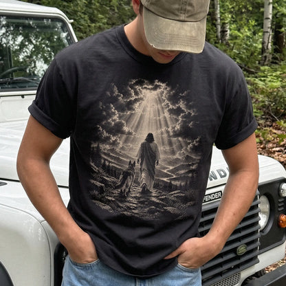 Person wearing a Black T-shirt with Jesus walking beside a German Shepherd beneath rays of light