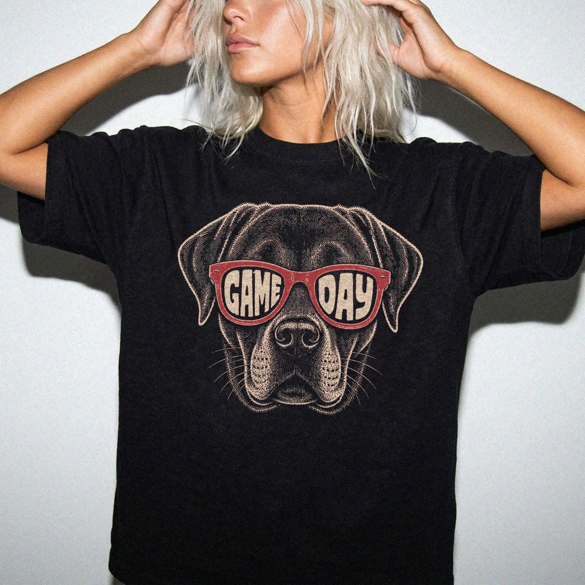 Model wearing a Black Comfort Colors® T-shirt with labrador retriever wearing red game day sunglasses