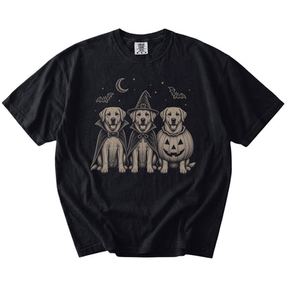 Three Labrador Retriever dogs dressed for Halloween beneath bats and a crescent moon on a Black Comfort Colors® T-shirt
