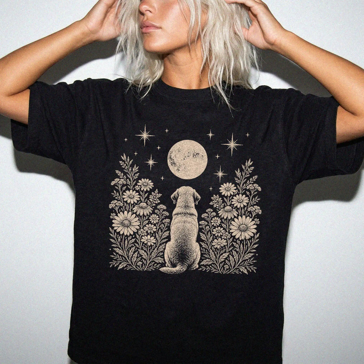 Model wearing a Black Comfort Colors® T-shirt featuring Labrador Retriever beneath a wildflower moon