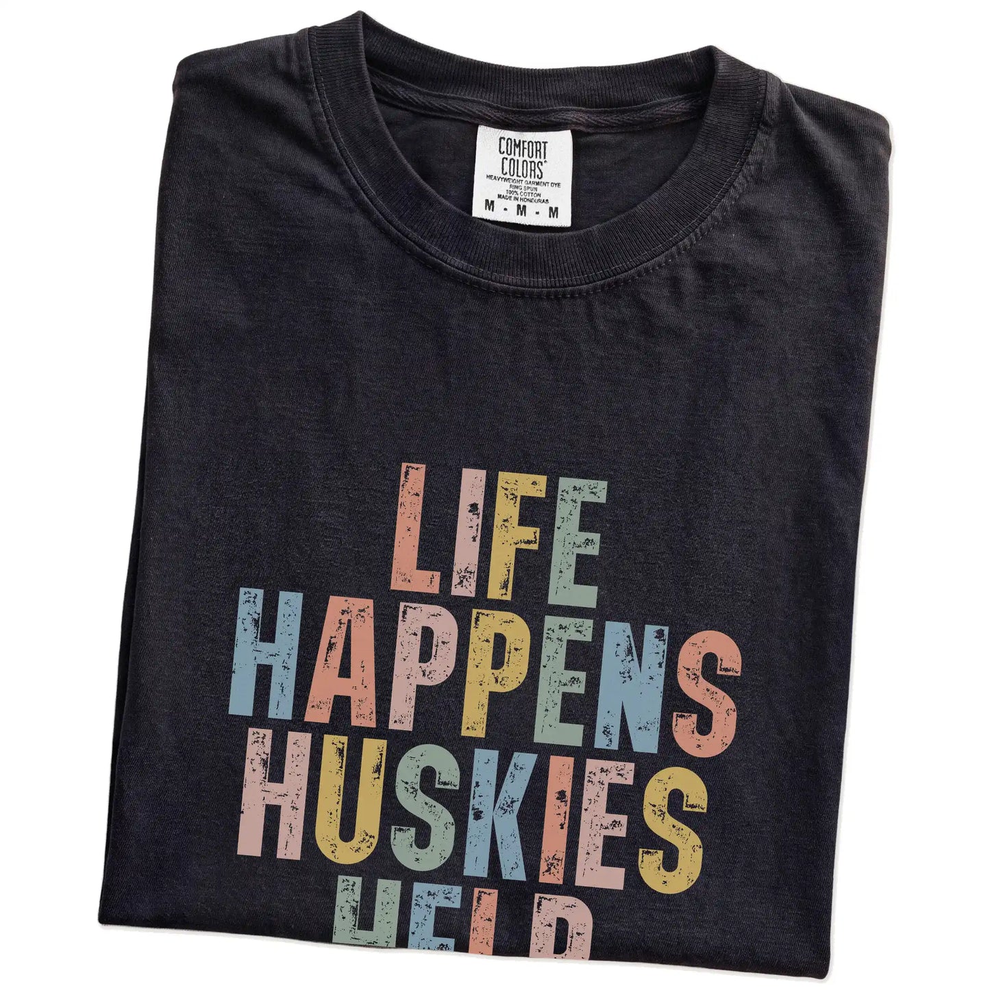 Folded Black Comfort Colors® T-shirt showing Husky making hard days better with “Life Happens, Dogs Help” lettering