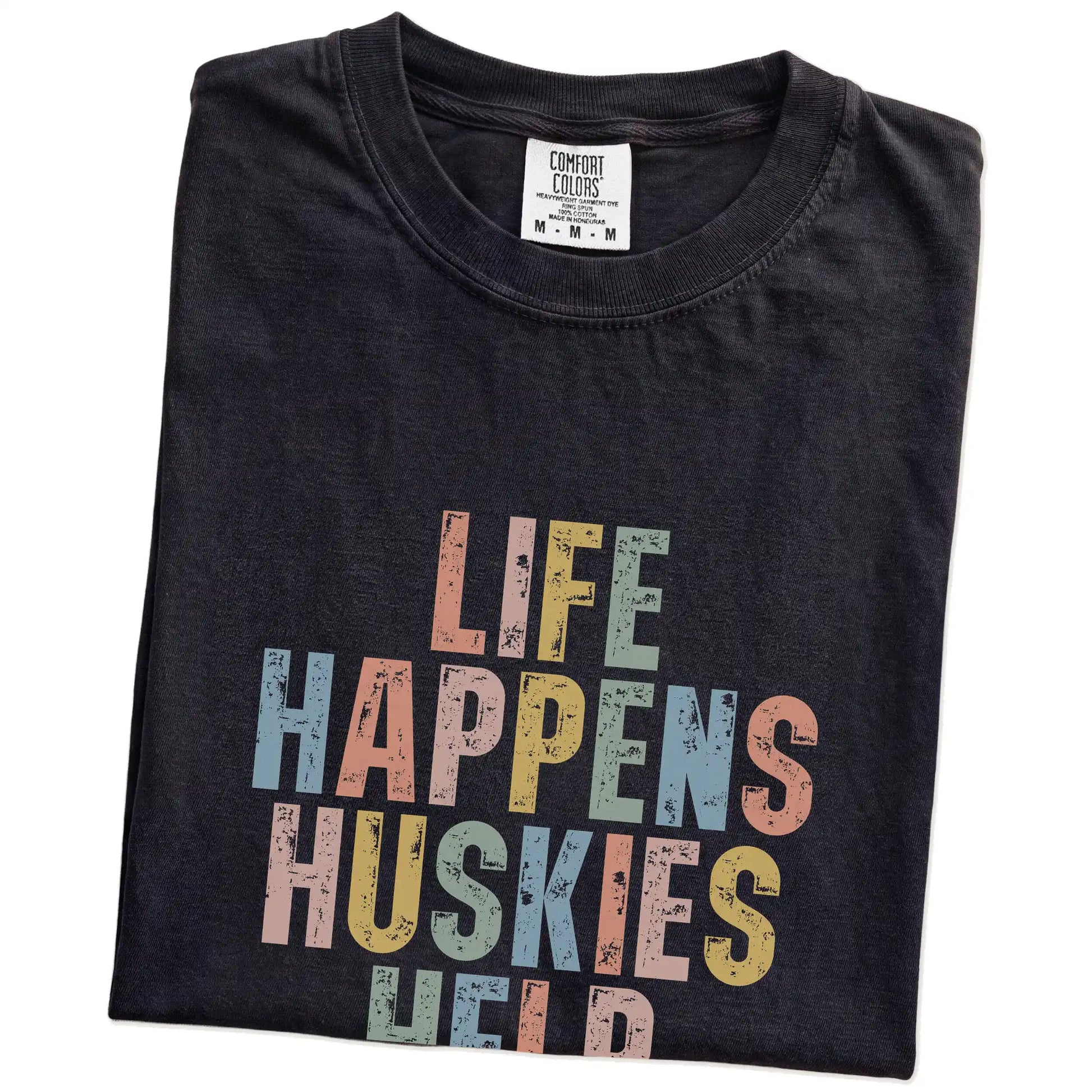 Folded Black Comfort Colors® T-shirt showing Husky making hard days better with “Life Happens, Dogs Help” lettering