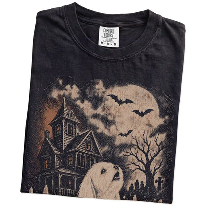 Folded Black Comfort Colors® T-shirt showing Maltese in a vintage haunted-house scene