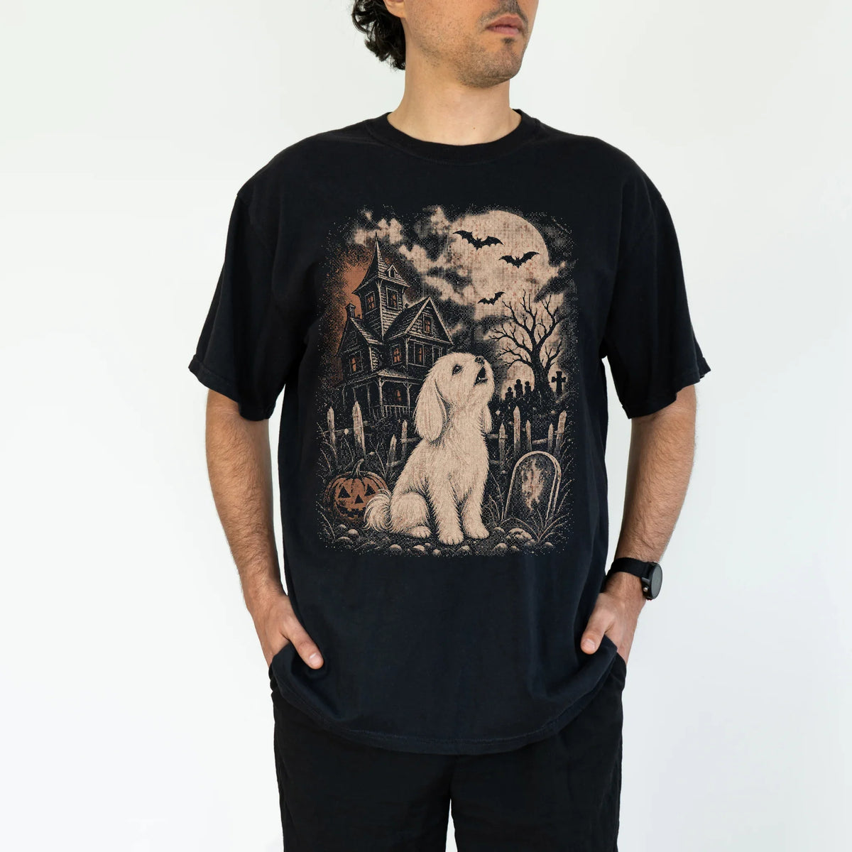 Model wearing a Black Comfort Colors® T-shirt showing Maltese in a vintage haunted-house scene