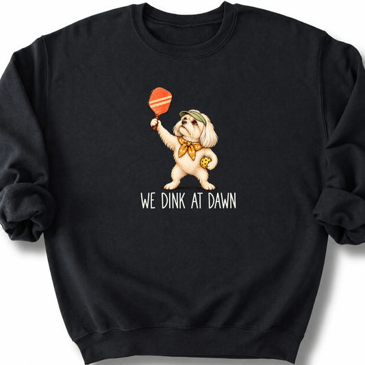 Maltese with a pickleball paddle and ball on a Black Gildan® sweatshirt with We Dink at Dawn text