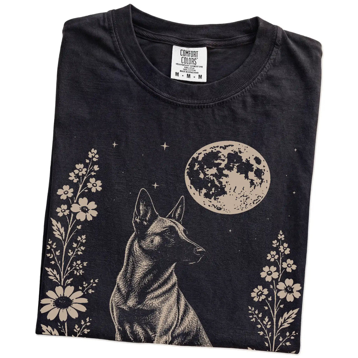 Folded Black Comfort Colors® T-shirt showing Belgian Malinois framed by flowers beneath the moon