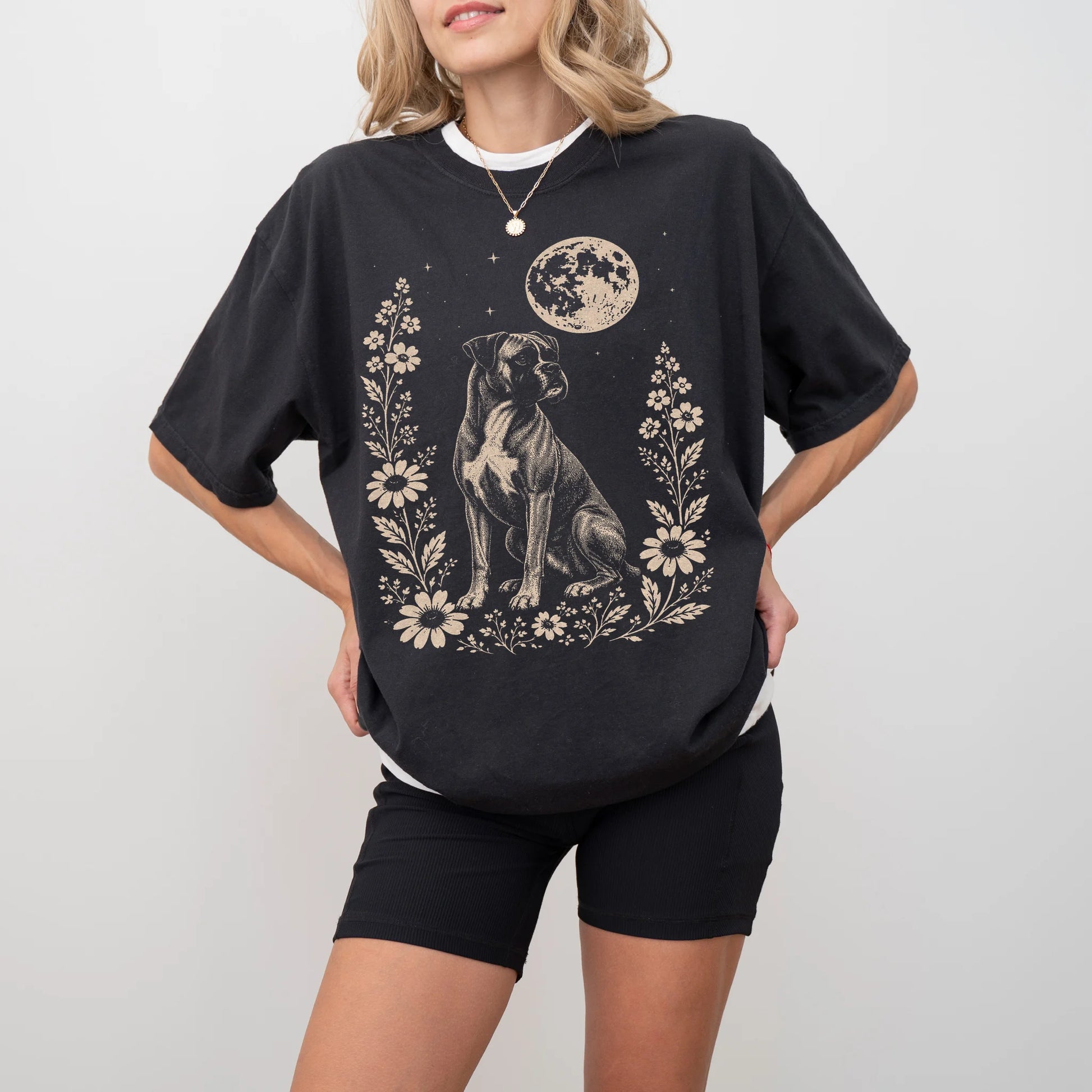 Model wearing a Black Comfort Colors® T-shirt featuring Boxer framed by flowers beneath the moon