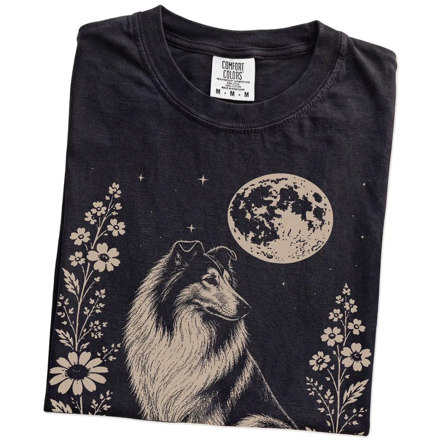 Folded Black Comfort Colors® T-shirt showing Collie framed by flowers beneath the moon