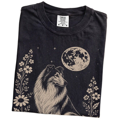 Folded Black Comfort Colors® T-shirt showing Collie framed by flowers beneath the moon