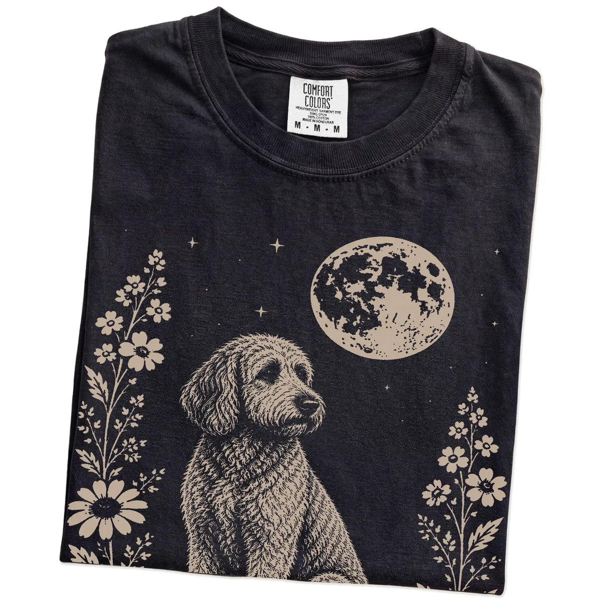 Folded Black Comfort Colors® T-shirt showing Labradoodle framed by flowers beneath the moon