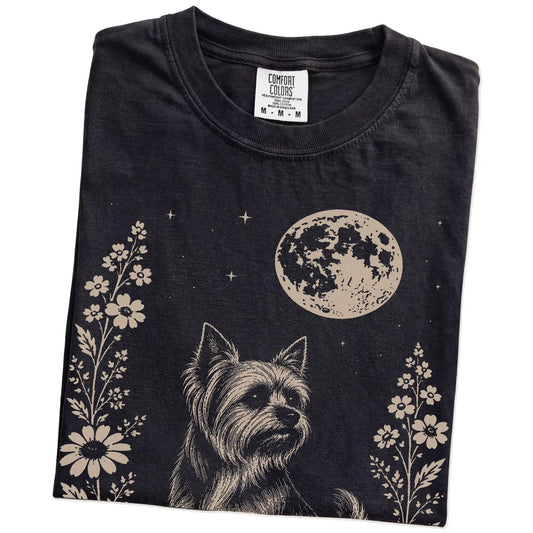 Folded Black Comfort Colors® T-shirt showing Yorkie framed by flowers beneath the moon