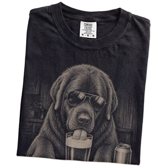 Folded Black Comfort Colors® t-shirt showing Newfie sneaking a drink from a pint