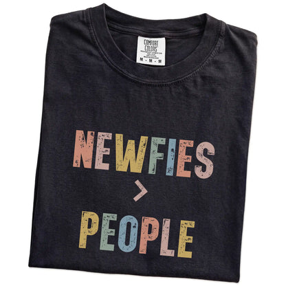 Folded Black Comfort Colors® T-shirt showing “Newfies > People” text