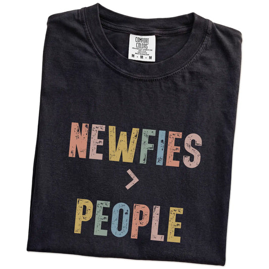 Folded Black Comfort Colors® T-shirt showing “Newfies > People” text