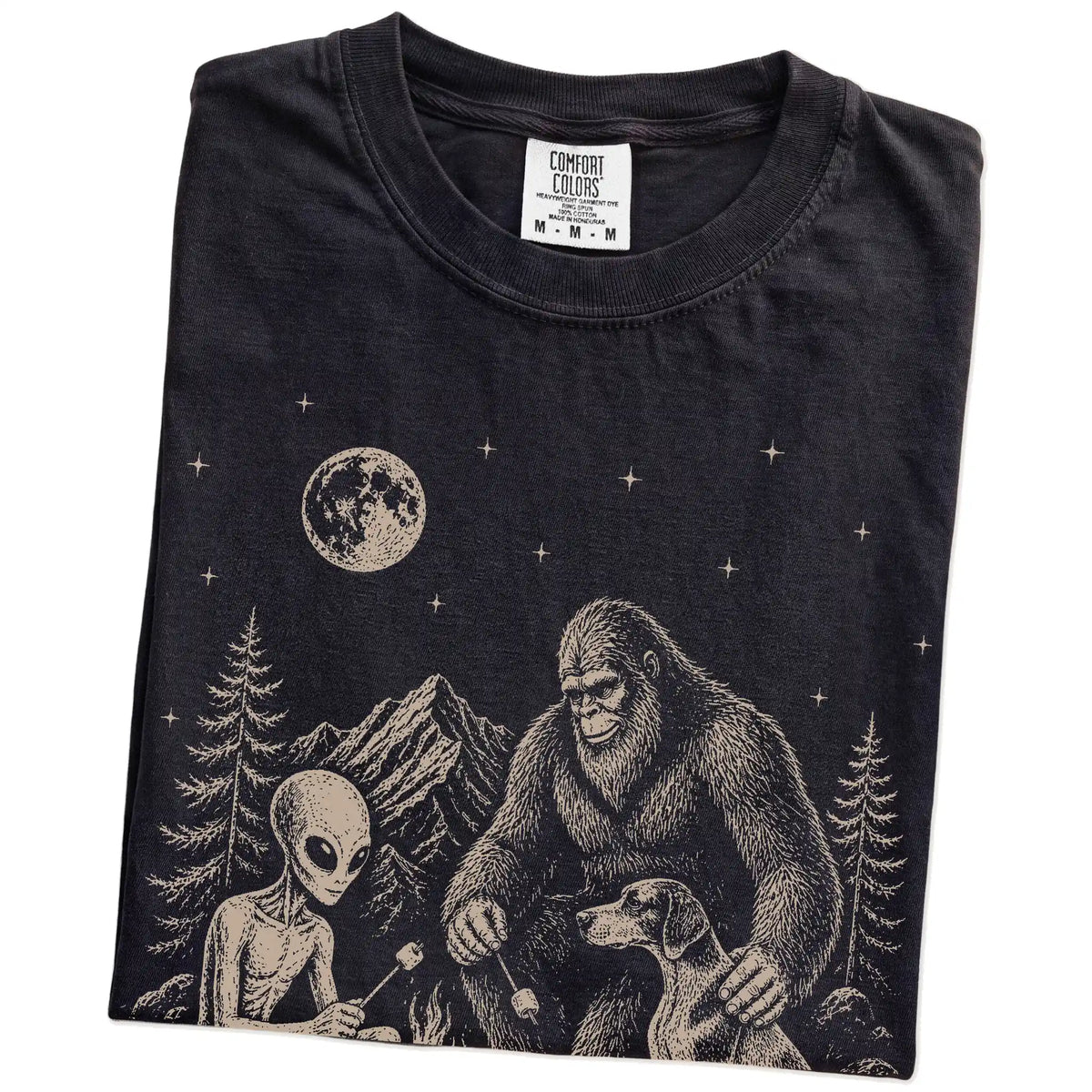 Folded Black Comfort Colors® T-shirt showing Pointer camping with Bigfoot and an alien