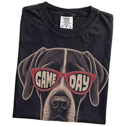 Folded Black Comfort Colors® T-shirt showing pointer wearing red game day sunglasses