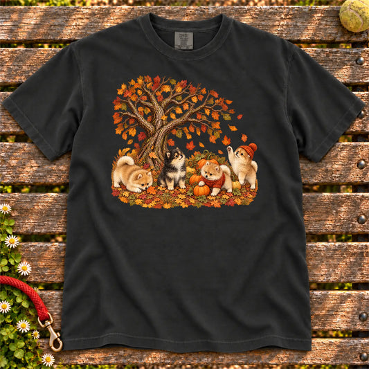 Four Pomeranian puppies with pumpkins beneath an autumn tree on a Black garment-dyed T-shirt