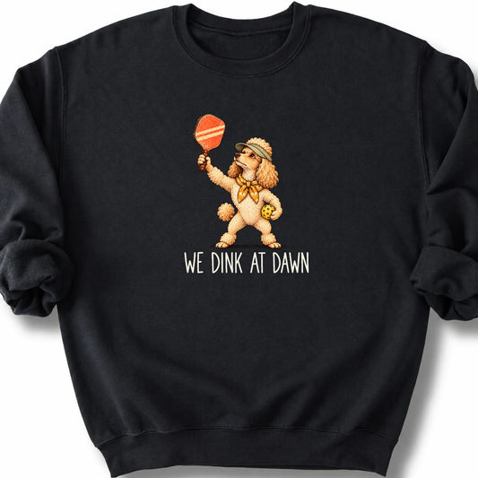 Poodle with a pickleball paddle and ball on a Black Gildan® sweatshirt with We Dink at Dawn text