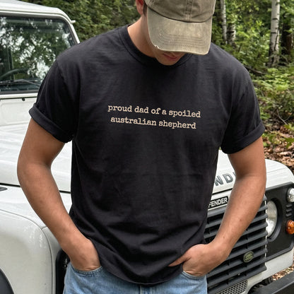 Model wearing a Black Comfort Colors® T-shirt with proud dad of a spoiled australian shepherd lettering