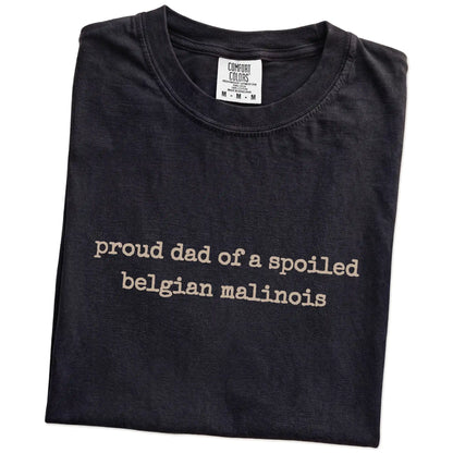 Folded Black Comfort Colors® T-shirt showing proud dad of a spoiled belgian malinois lettering