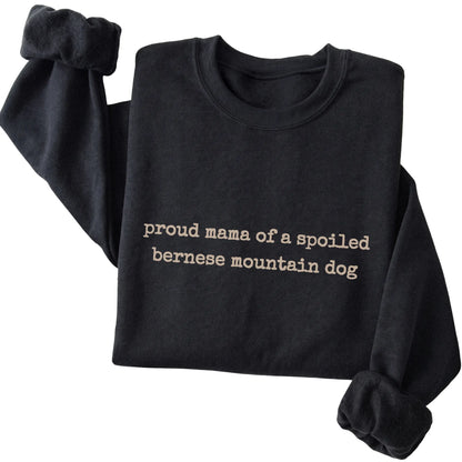 Black Proud Mama of a Spoiled Bernese Mountain Dog sweatshirt folded to show the printed design