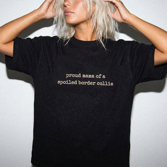 Model wearing a Black Comfort Colors® T-shirt featuring Proud Mama of a Spoiled Border Collie lettering