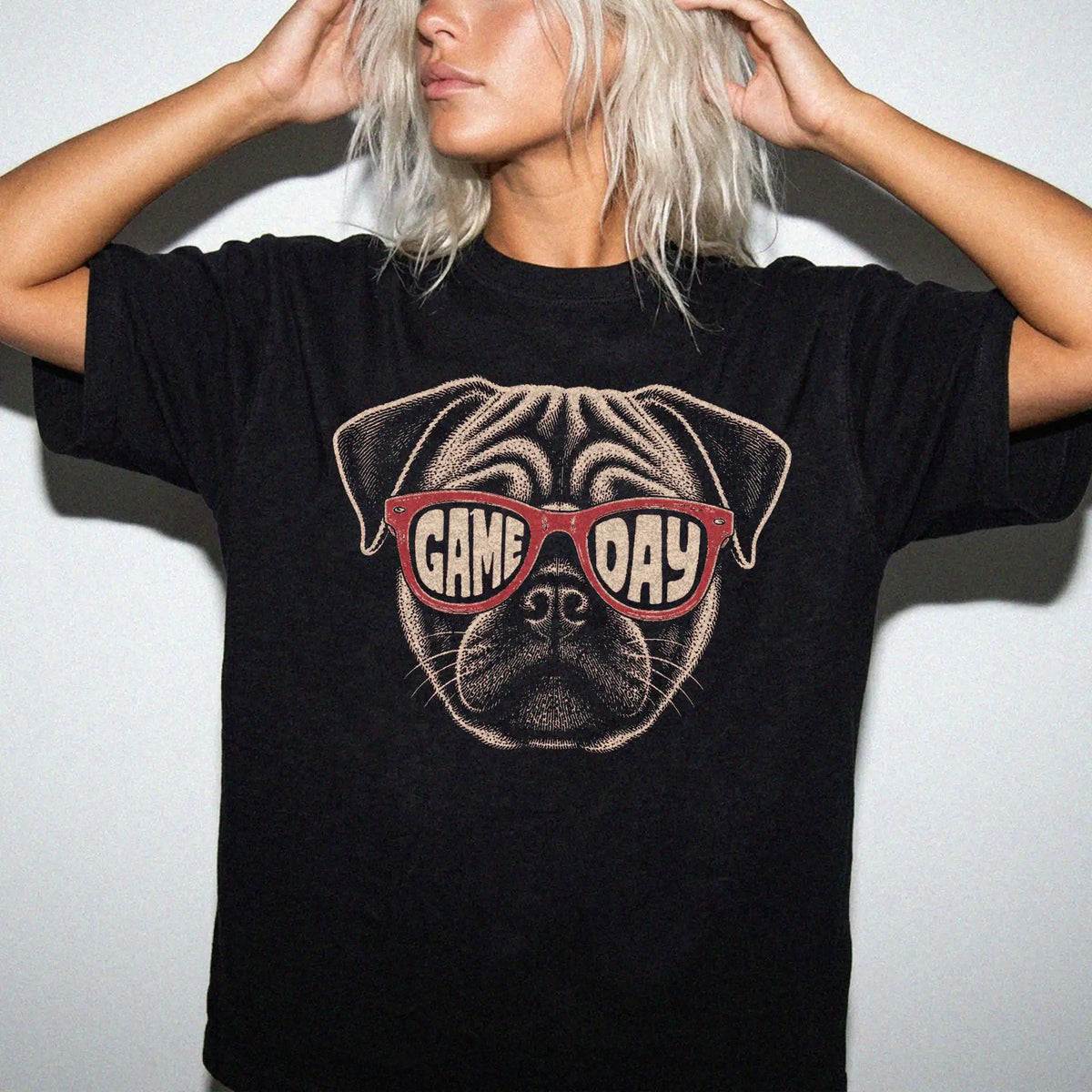Model wearing a Black Comfort Colors® T-shirt with pug wearing red game day sunglasses