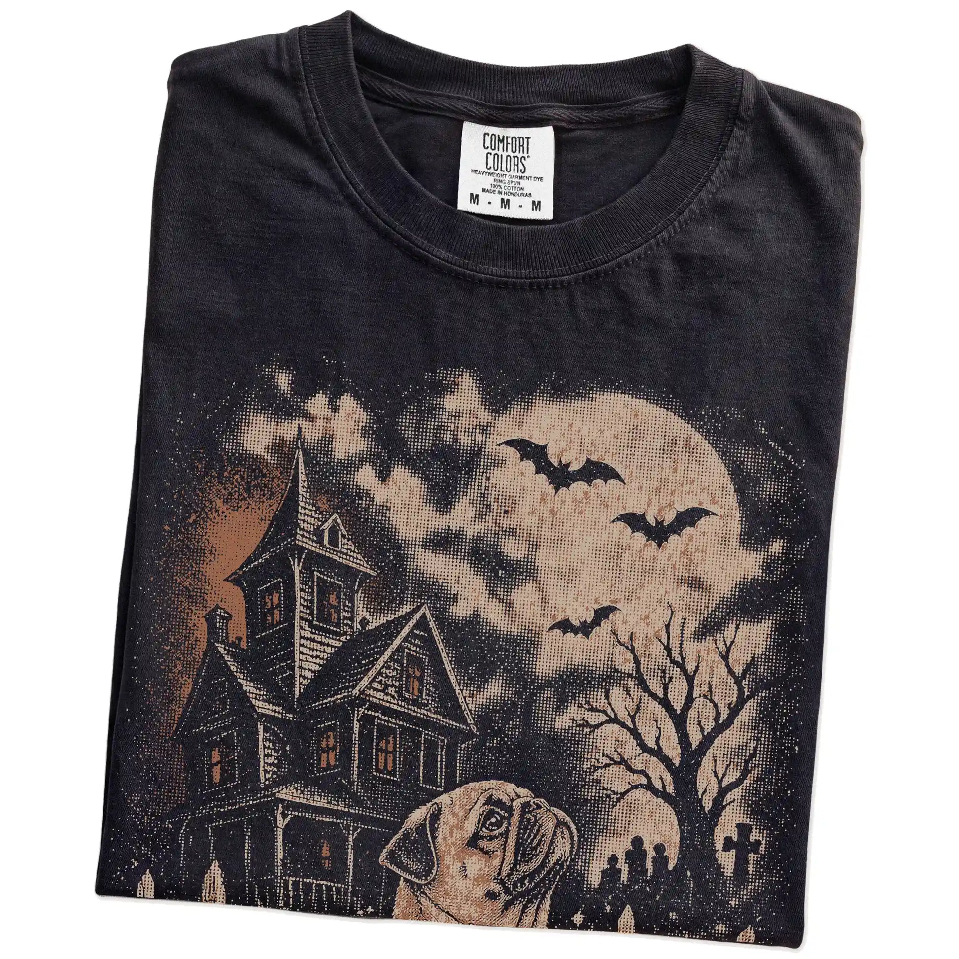 Folded Black Comfort Colors® T-shirt showing Pug in a vintage haunted-house scene