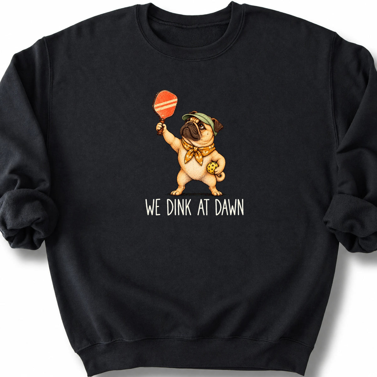 Pug with a pickleball paddle and ball on a Black Gildan® sweatshirt with We Dink at Dawn text