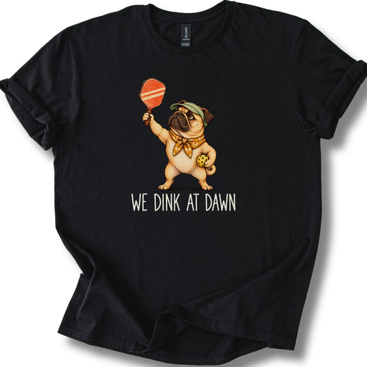 Pug with a pickleball paddle and ball on a Black Gildan® T-shirt with We Dink at Dawn text