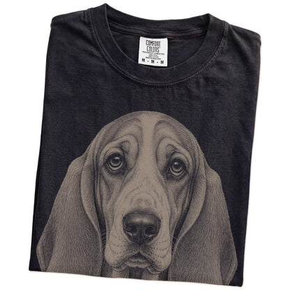 Folded Black Comfort Colors® T-shirt showing a realistic drawing of a Basset Hound