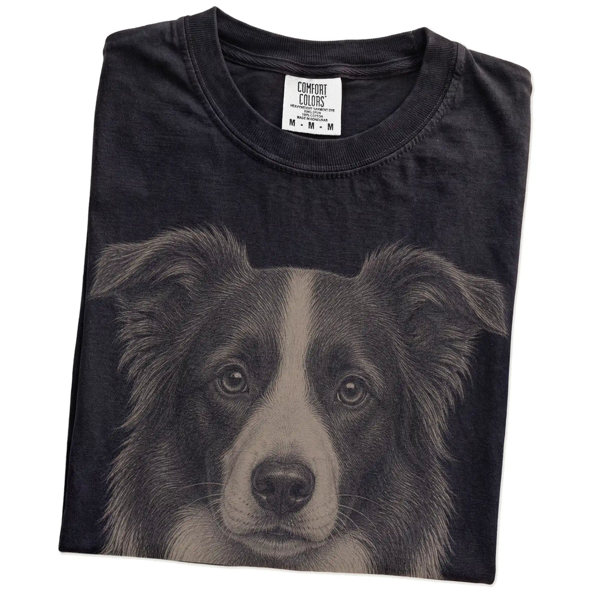 Folded Black Comfort Colors® T-shirt showing a realistic drawing of a Border Collie