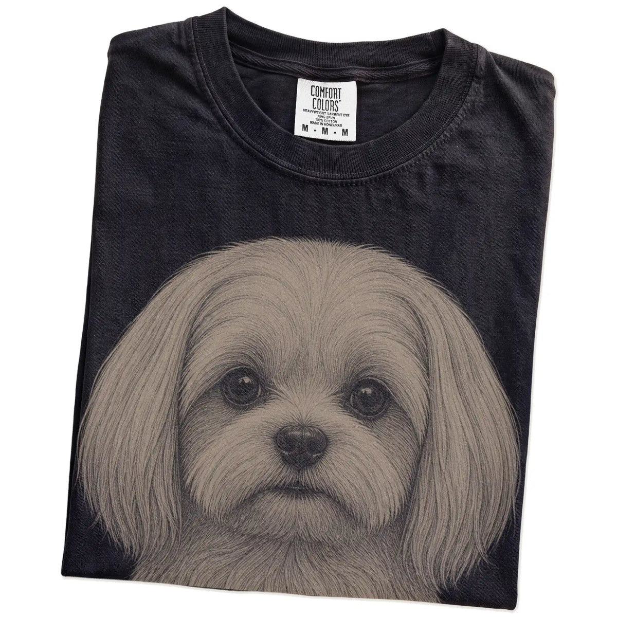 Folded Black Comfort Colors® T-shirt showing a realistic drawing of a Maltese