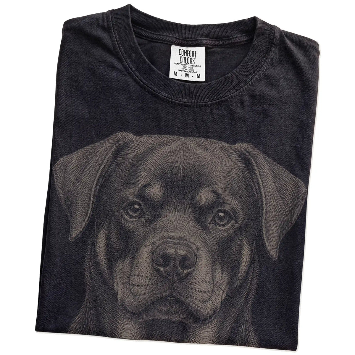 Folded Black Comfort Colors® T-shirt showing a realistic drawing of a Rottweiler
